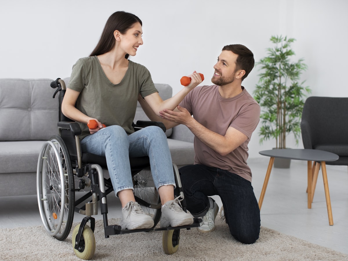 A support worker gently assisting a woman who uses a wheelchair during a session